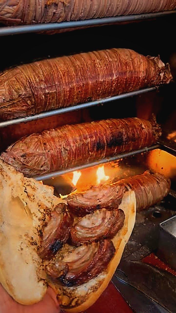 Tahta tabakta kokoreç porsiyonu, yanında kızarmış biber ve ekmek